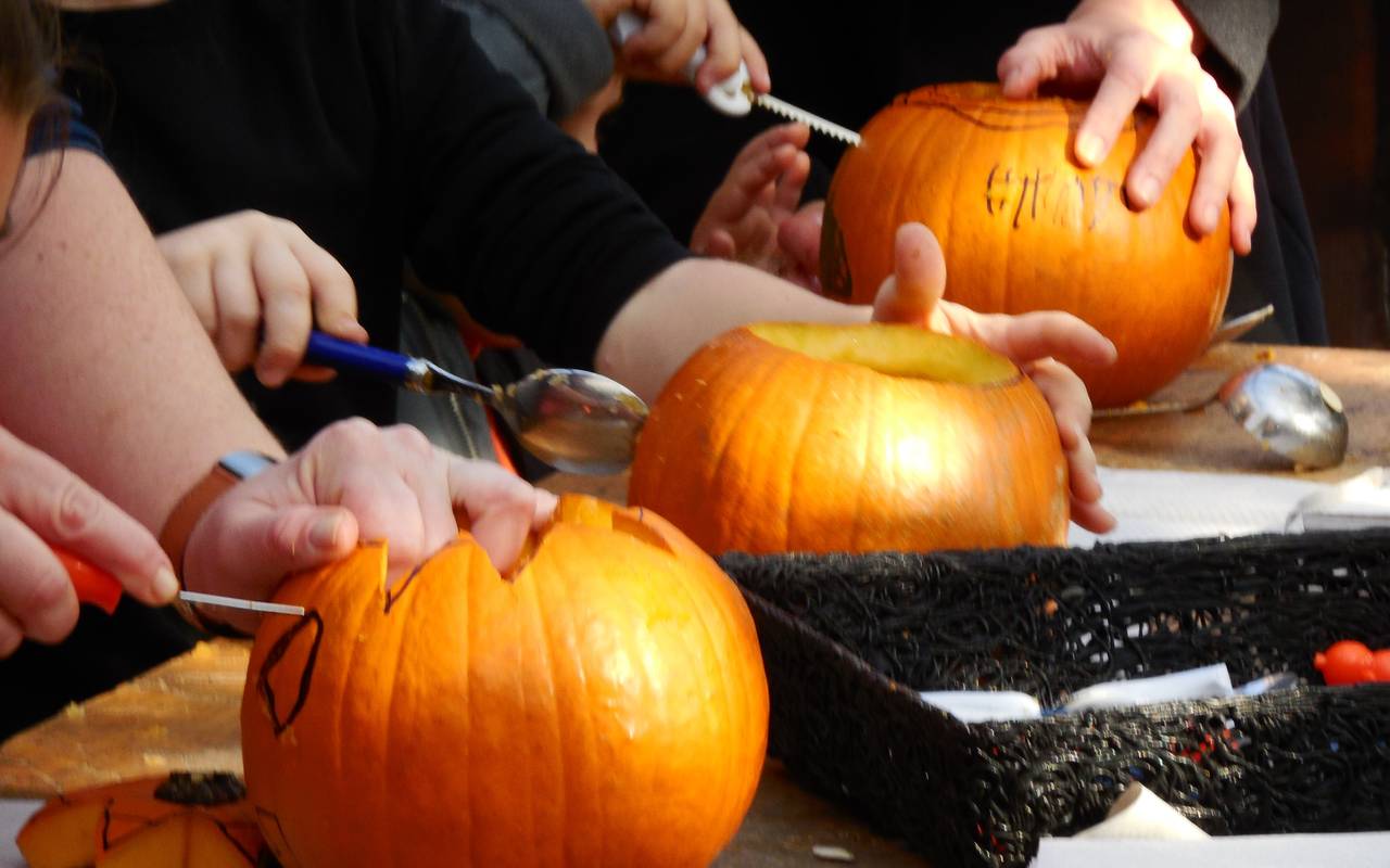 Kinder beim Schnitzen von Kürbissen.