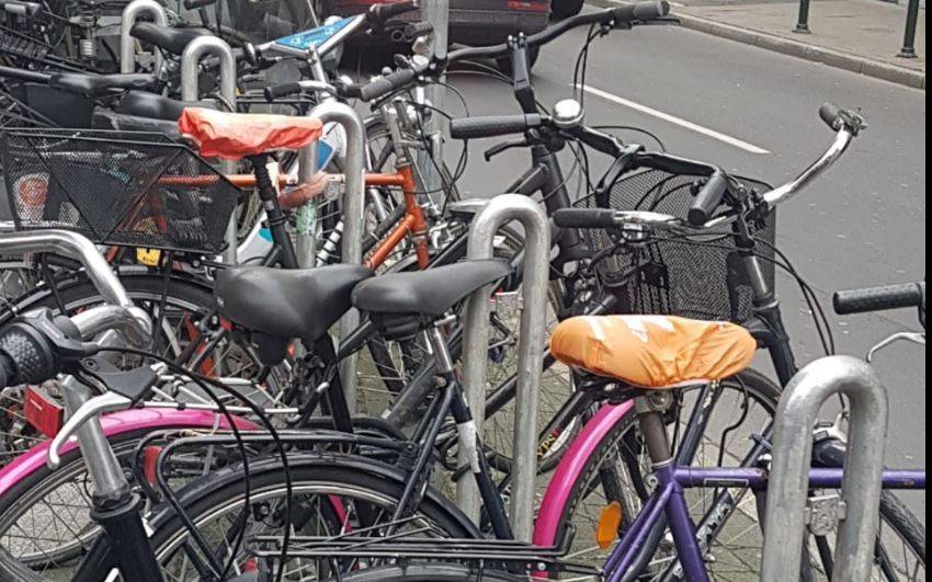 Mehrere Fahrräder stehen an einem Fahrradständer an einer Straße in Düsseldorf.