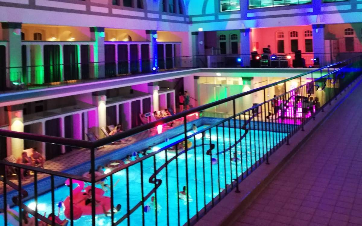 Die atmosphärisch beleuchtete Münstertherme. Die Beleuchtung ist bunt.