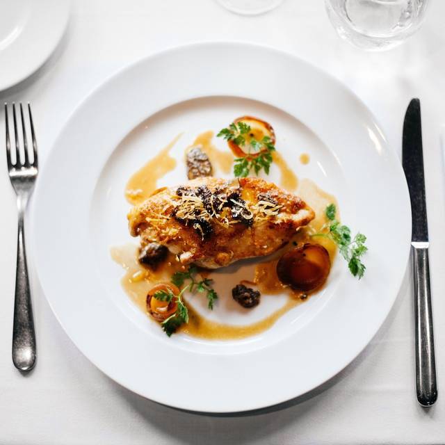 Ein schön angerichteter Teller mit Essen. Er steht auf einem gedeckten Tisch.