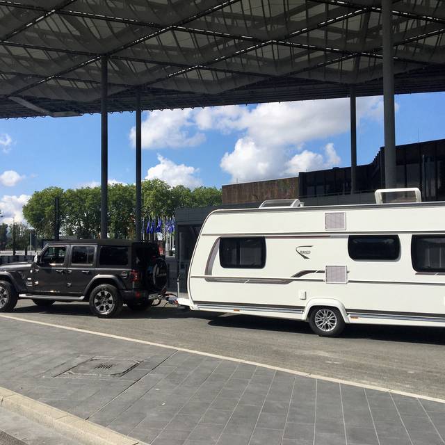 Ein Wohnwagen steht vor dem Eingang der Messe "Caravan Salon".