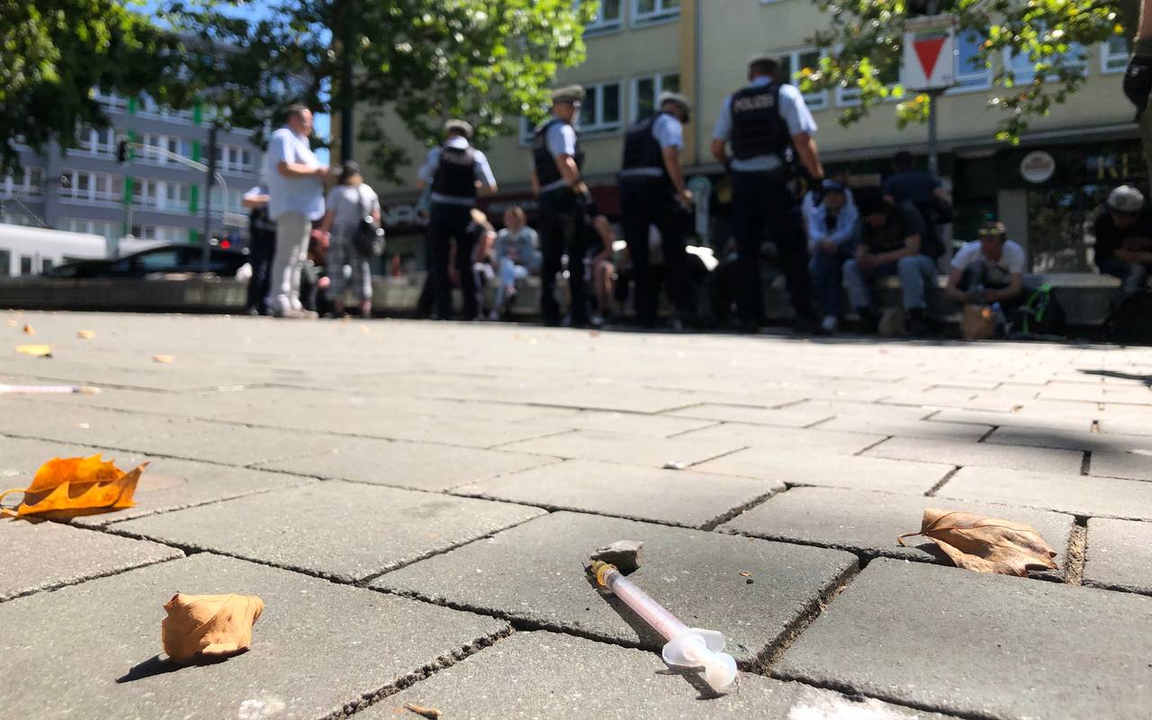 Polizisten im Einsatz auf dem Worringer Platz. Sie kontrollieren Personen, die auf Bänken sitzen.