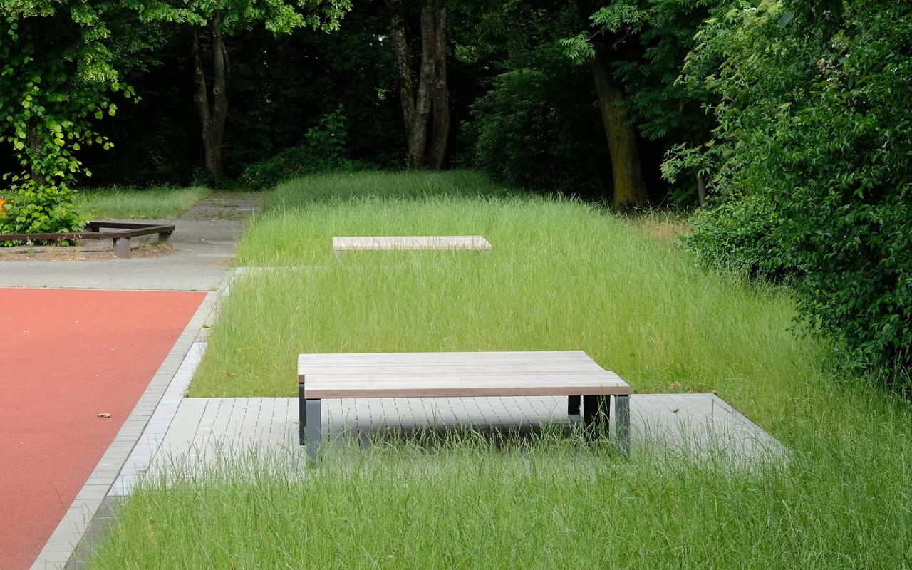 Grüne Rasenfläche mit einer grauen Sitzfläche