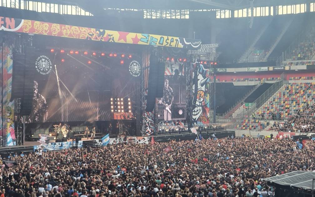 Ein Bild aus der Arena in Stockum. Es ist die Bühne der Toten Hosen bei einem Konzert. Der Innenraum ist voller Menschen.