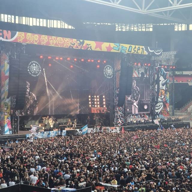 Ein Bild aus der Arena in Stockum. Es ist die Bühne der Toten Hosen bei einem Konzert. Der Innenraum ist voller Menschen.