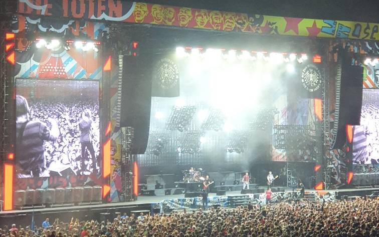 Ein Bild aus der Arena in Stockum. Es ist die Bühne der Toten Hosen bei einem Konzert. Der Innenraum ist voller Menschen.