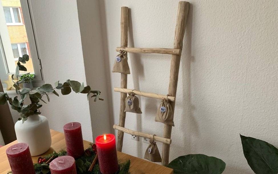 Selbstgemachter Adventskalender, im Vordergrund ein Adventskranz