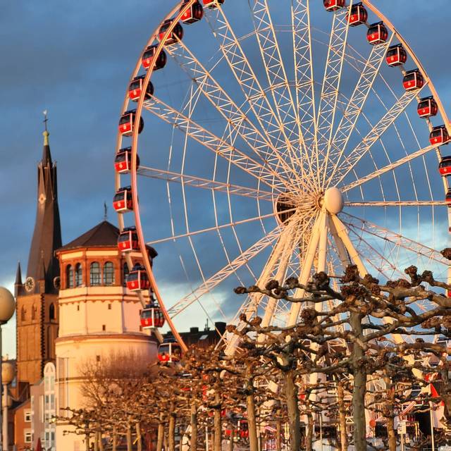 Düsseldorfer Wahrzeichen im Sonnenlicht. Der Schlossturm, St. Lambertus und das Riesenrad auf dem Burgplatz sind zu sehen.