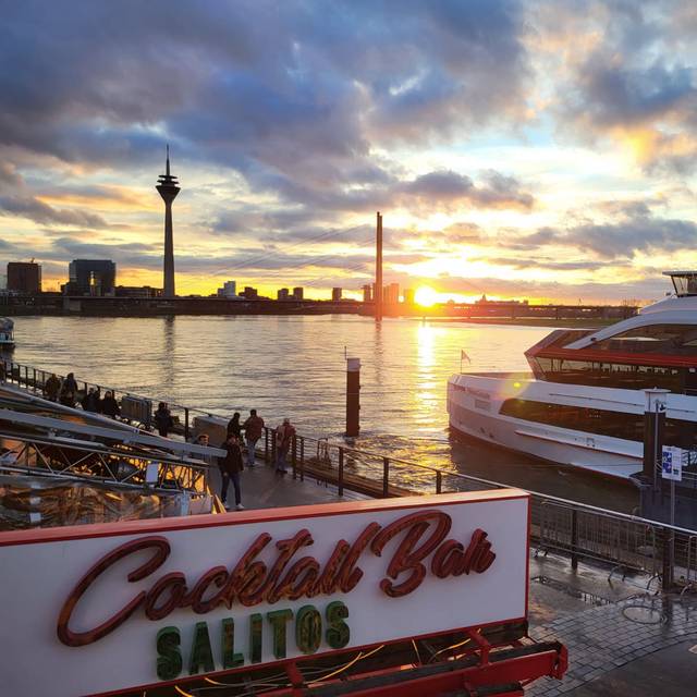 Die Rheinuferpromenade mit Sonnenuntergang und Rheinturm.