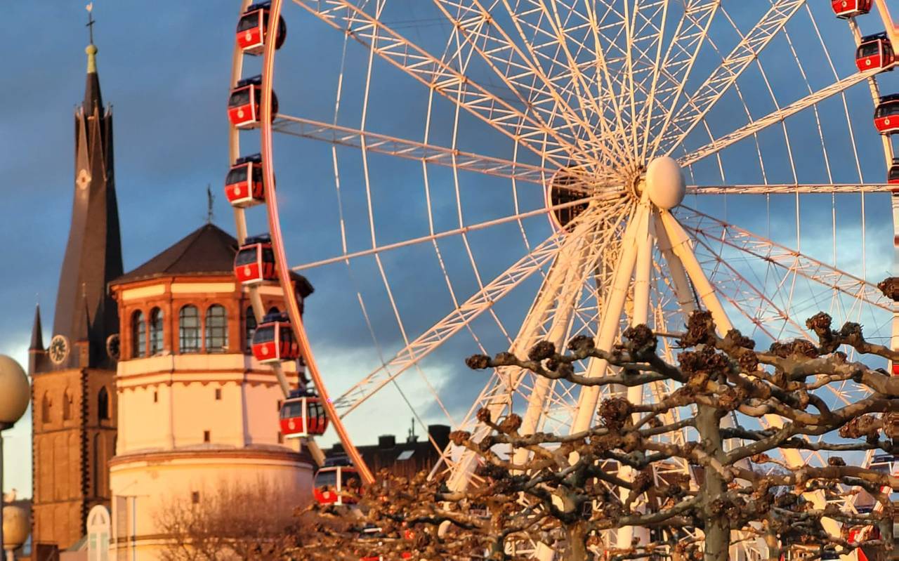 Düsseldorfer Wahrzeichen im Sonnenlicht. Der Schlossturm, St. Lambertus und das Riesenrad auf dem Burgplatz sind zu sehen.