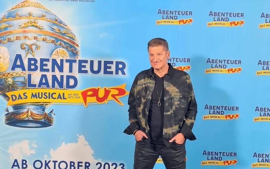 Pur-Sänger Hartmut Engler vor einer Werbewand für sein Musical.
