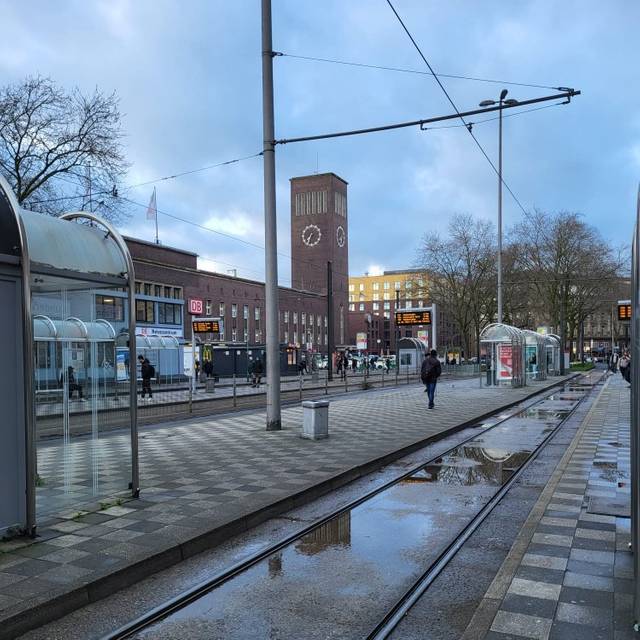 Die Rheinbahnhaltestelle vor dem Düsseldorfer Hauptbahnhof. Das Wetter ist eher ungemütlich und grau.