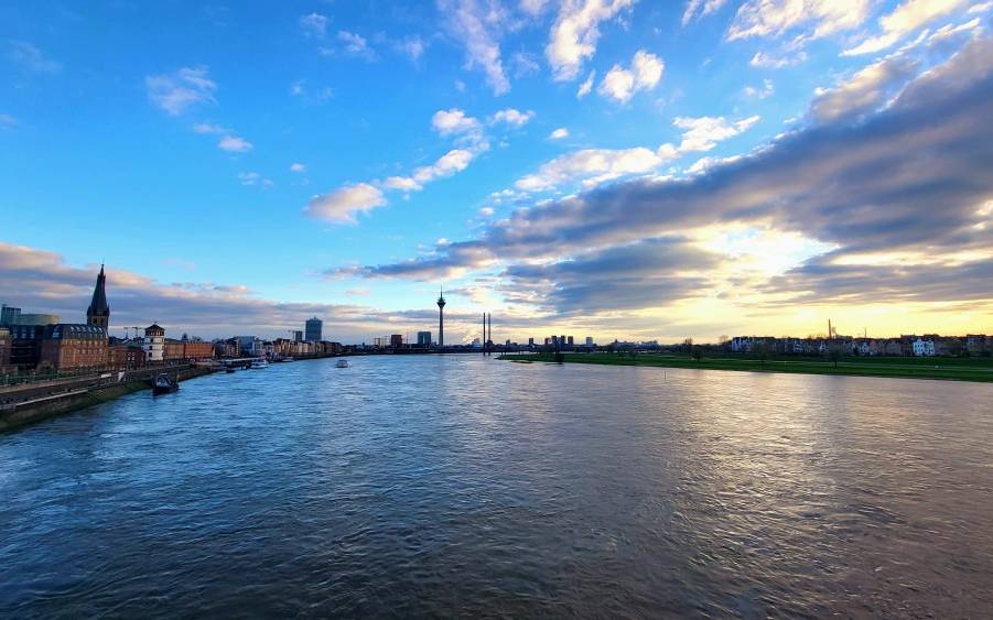 Im Vordergrund ist der Rhein zu sehen, im Hintergrund die Skyline von Düsseldorf.