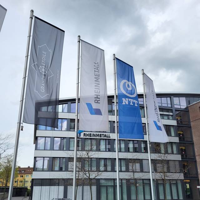 Die Firmenzentrale von Rheinmetall in Düsseldorf. Vor dem Gebäude wehen Rheinmetall-Fahnen.