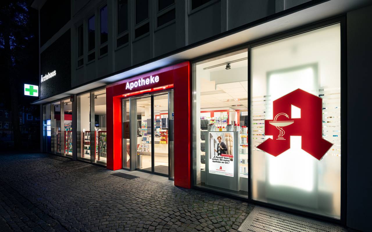 Die Frontansicht einer Apotheke. Es ist dunkel.