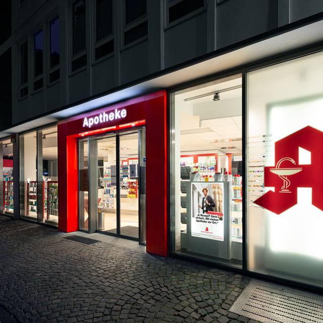 Die Frontansicht einer Apotheke. Es ist dunkel.