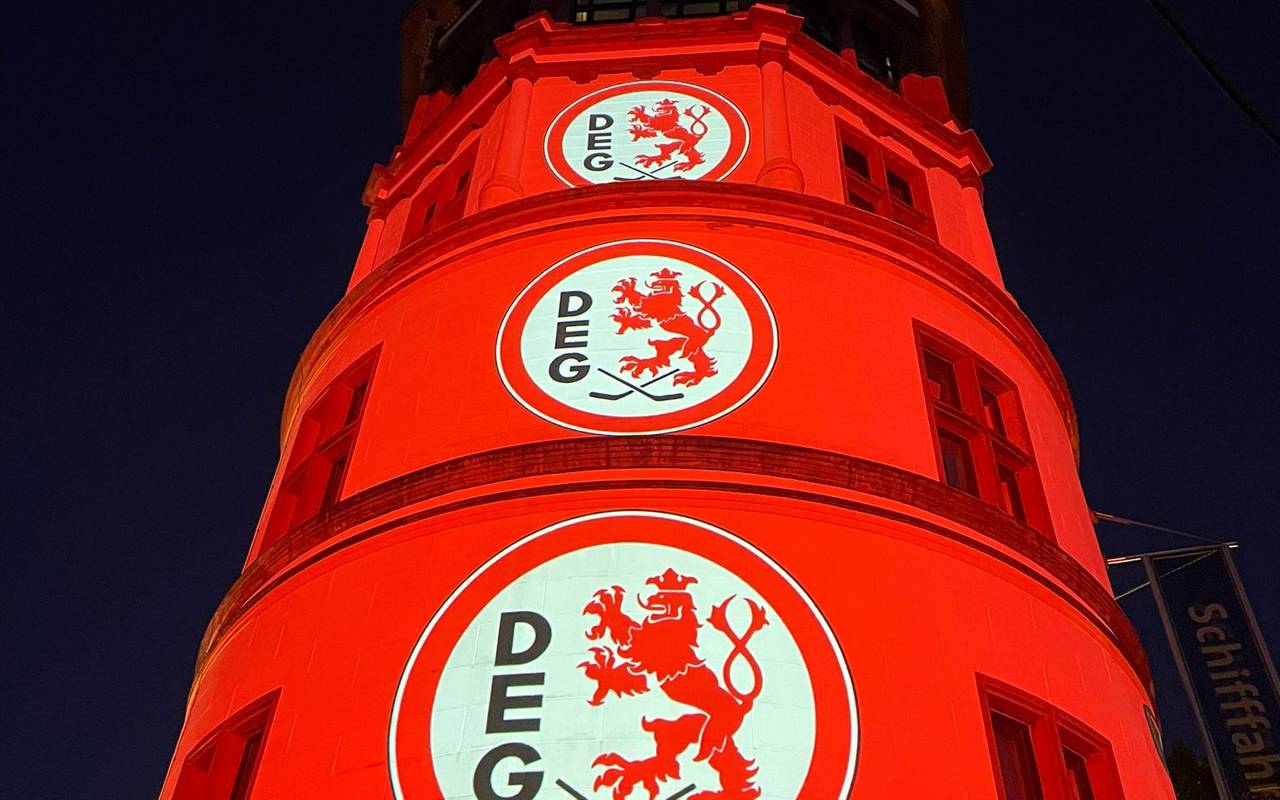 Der Schlossturm an Burgplatz wird mit Licht und DEG-Logos angestrahlt.