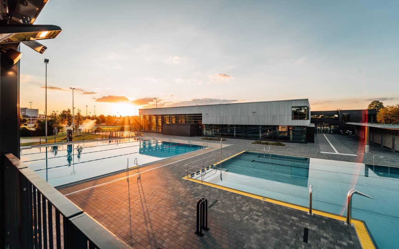 Das Allwetterbad in Flingern mit Schwimmbecken und Sonnenuntergang.