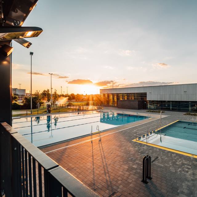 Das Allwetterbad in Flingern mit Schwimmbecken und Sonnenuntergang.