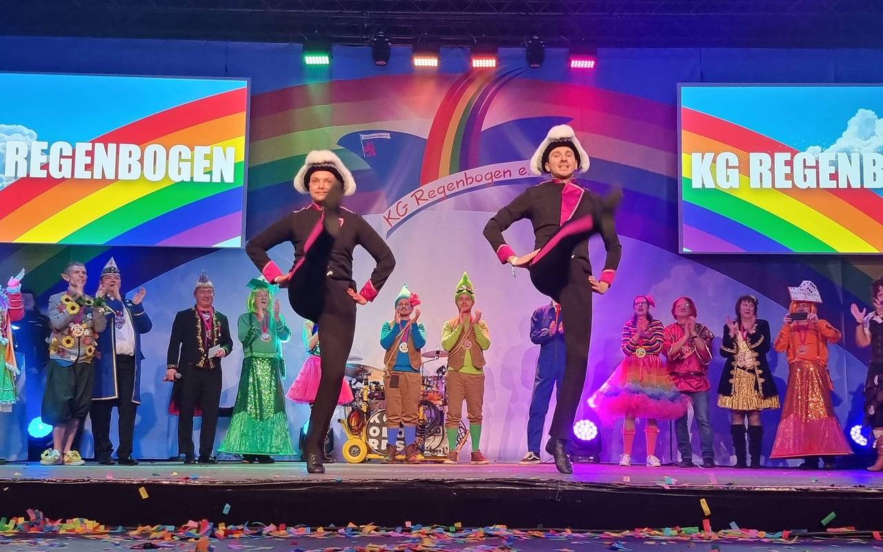 Das Tanzpaar der KG Regenbogen bei einem Auftritt. Beide Tänzer tanzen auf einer Bühne.