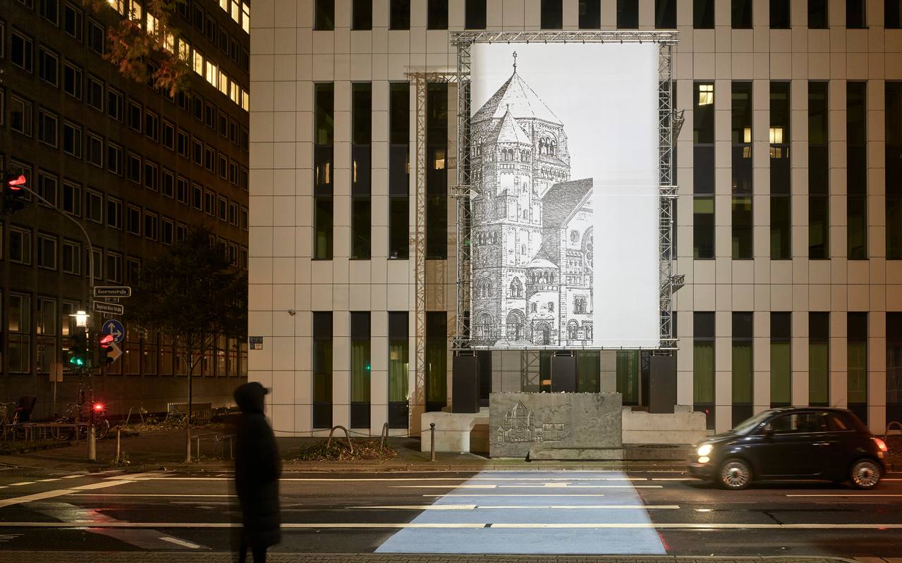 Die Lichtinstallation "missing link_" des Konzeptkünstlers Mischa Kuball. Zu sehen ist eine schwarz-weiß-Abbildung eines Teils der historischen Synagoge auf einer beleuchteten Glasplatte an einer modernen Gebäudefassade.