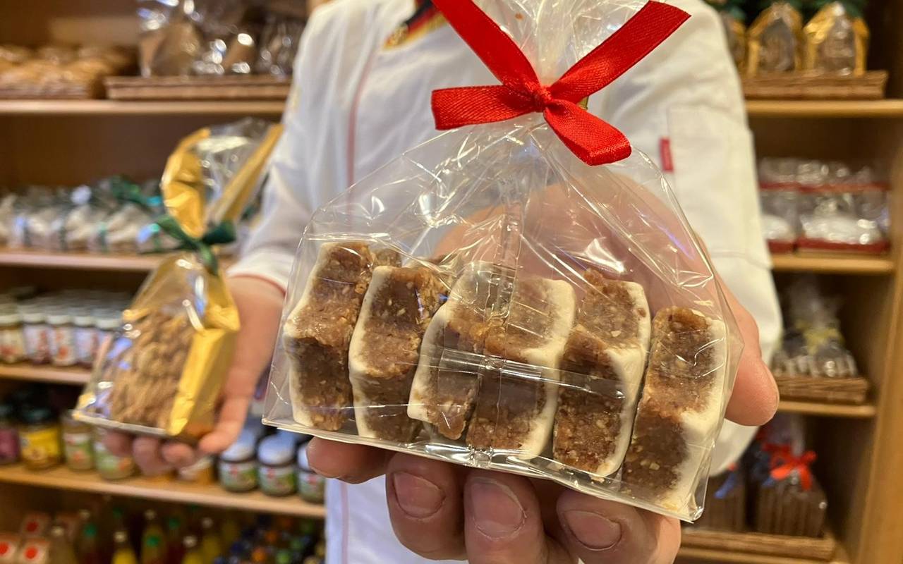 Ein Bäcker hält verpackte Weihnachtsplätzchen in der Hand.
