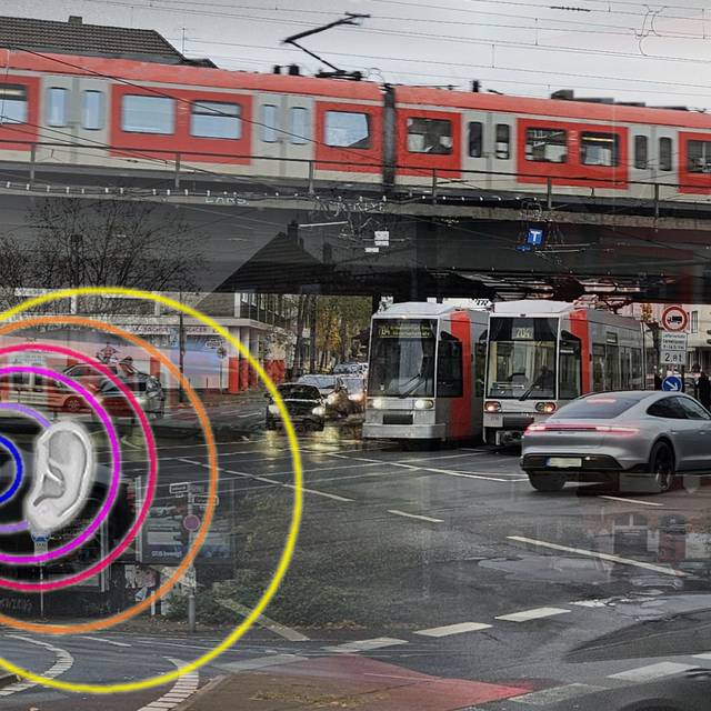 Eine Kreuzung mit Autos, Bahnen und einer S-Bahn. Krach