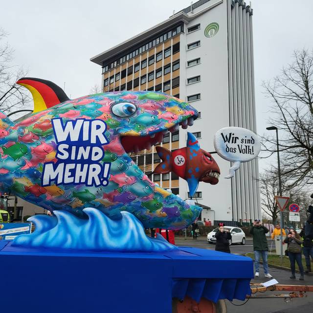 Ein Mottowagen im Rosenmontagszug. Ein großer Fisch frisst einen kleinen AfD-Fisch.