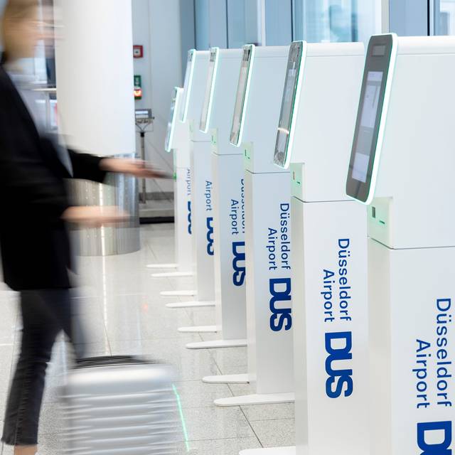 Gepäckschalter am Düsseldorfer Flughafen. Ein Passagier checkt sein Gepäck selber ein.