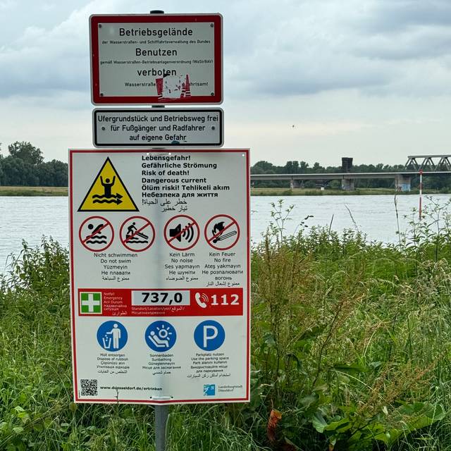 Hinweisschilder warnen vor dem Baden im Rhein.