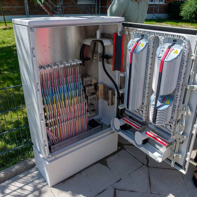 Ein geöffneter Kasten mit Kabeln. Es handelt sich um Glasfaserkabel.
