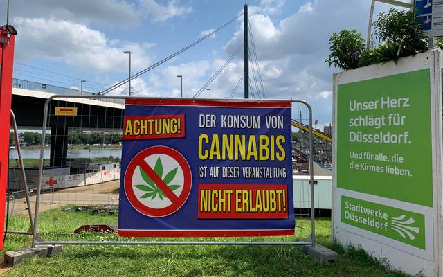 Cannabis-Verbot auf der Rheinkirmes. Darauf macht ein Schild auf den Rheinwiesen aufmerksam.