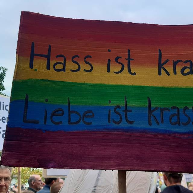 Ein Demo-Plakat in Regenbogenfarben mit dem Satz "Hass ist krass - Liebe ist krasser".