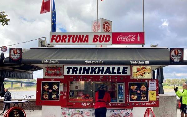 Eine Kundin steht vor dem Fortuna-Büdchen am Rhein.