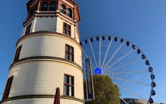 Schlossturm auf dem Burgplatz mit Riesenrad im Hintergrund.