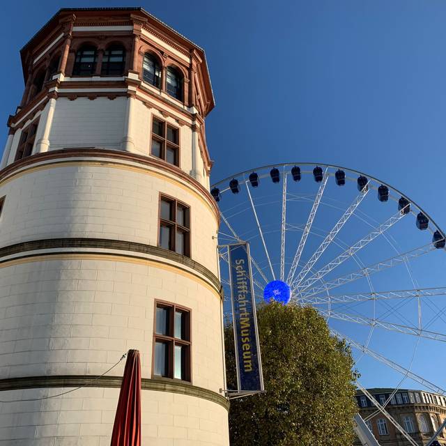 Schlossturm auf dem Burgplatz mit Riesenrad im Hintergrund.