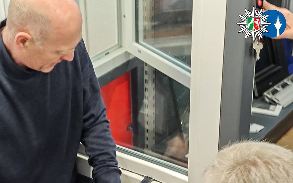 Ein Polizist demonstriert mit Einbruchswerkzeug, wie eingebrochen wird. Er hebelt ein Fenster auf.