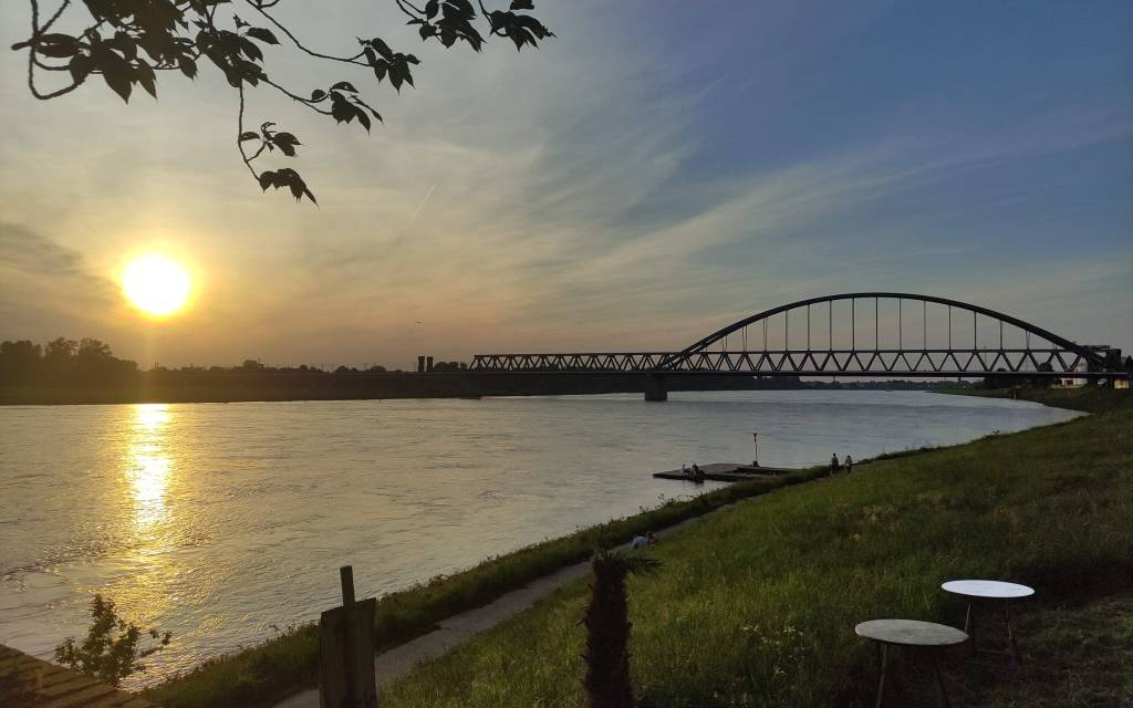 Die Eisenbahnbrücke in Hamm im Sonnenuntergang. Die Sonne spielgelt sich im Rhein wider.