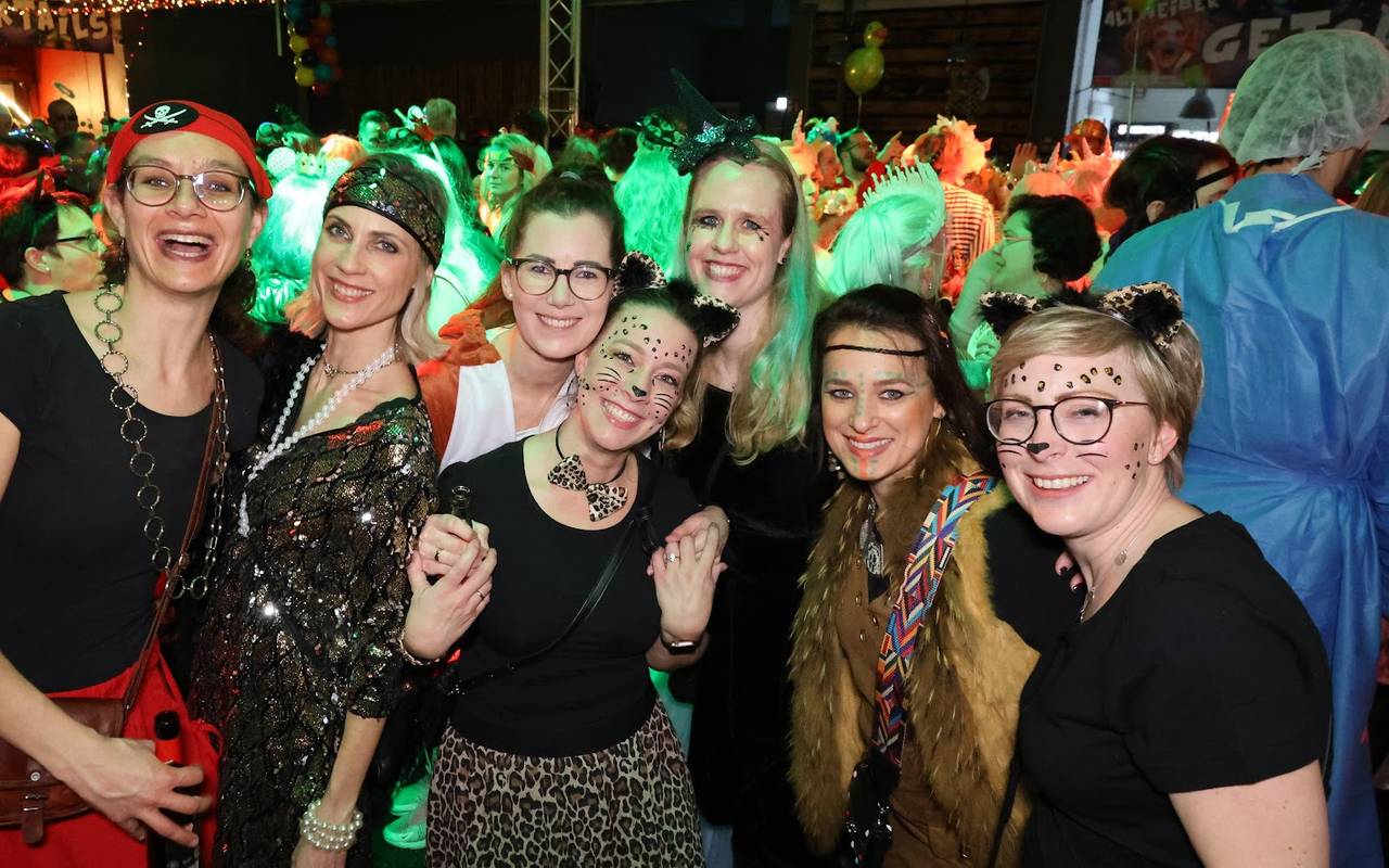 Ausgelassene Stimmung bei einer Altweiber-Party. Die Gruppe ist vergnügt und lächelt verkleidet in die Kamera.