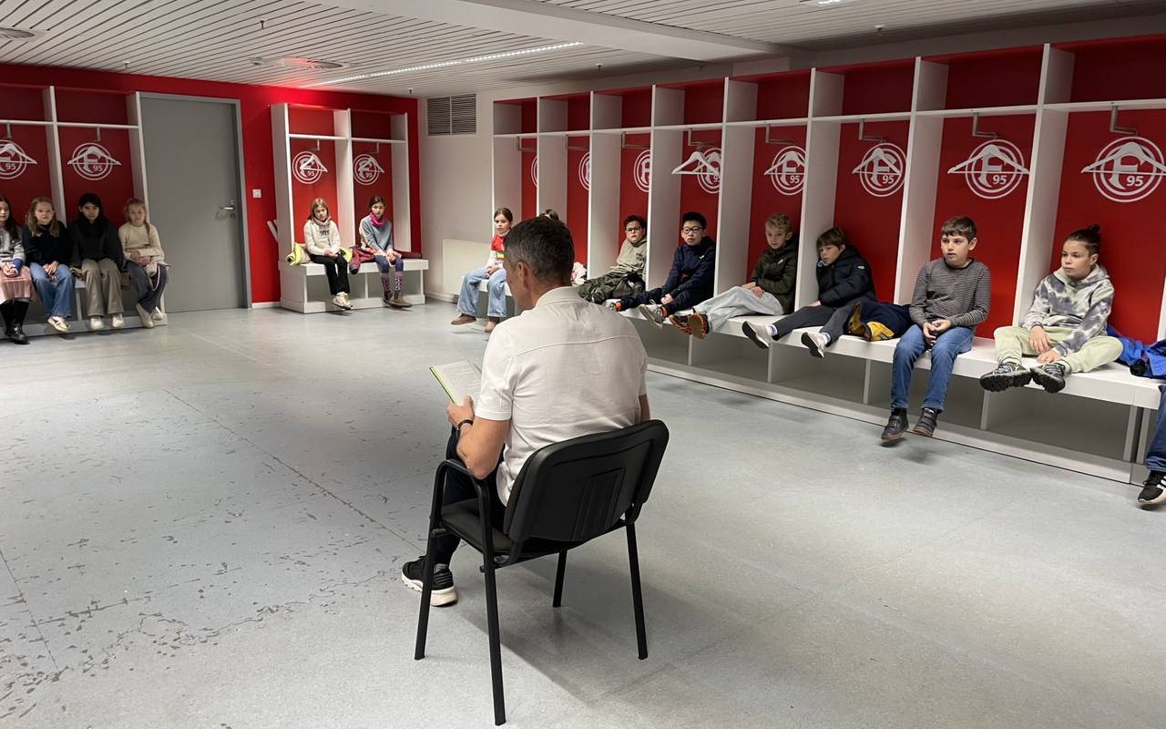 Fortuna-Legende Oliver Fink in der Heim-Kabine von Fortuna Düsseldorf. Er liest Kindern aus Niederkassel aus dem Buch "Woodwalkers" vor.