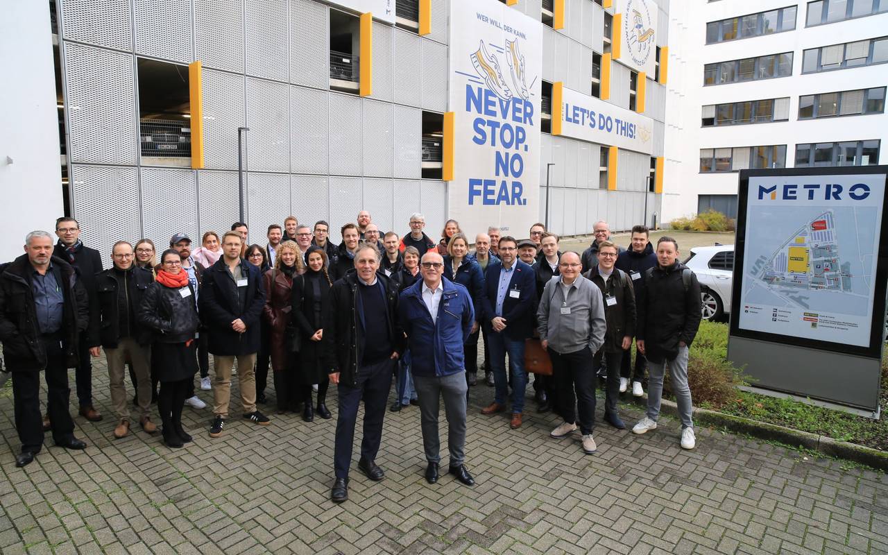 Beim Netzwerktreffen der Düsseldorfer Mobilitätspartner stehen Vertreter der Firmen und Umweltdezernent Jochen Kral vor der METRO.