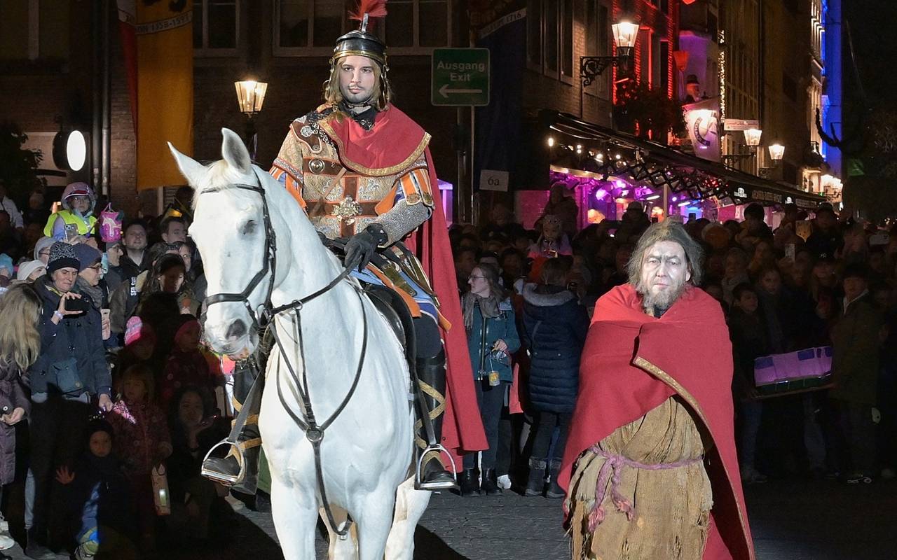 St. Martin hat seinen Mantel mit einem armen Mann geteilt. Der Marktplatz ist voller Menschen.