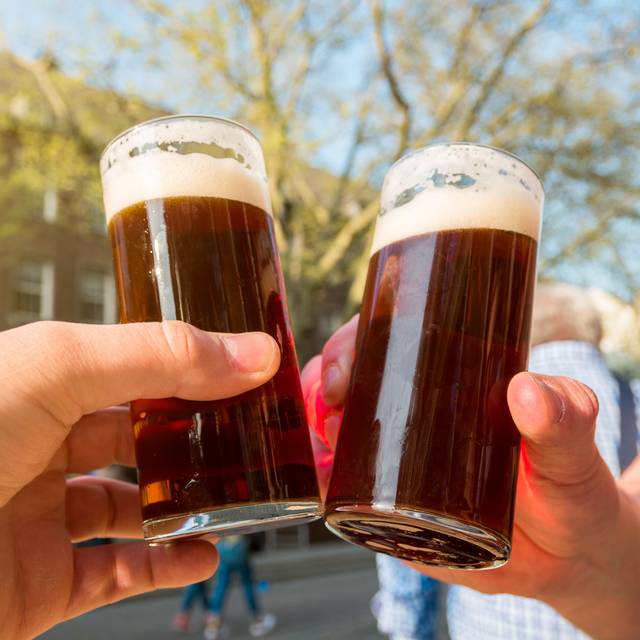 Zwei Personen stoßen mit zwei Altbiergläsern an.