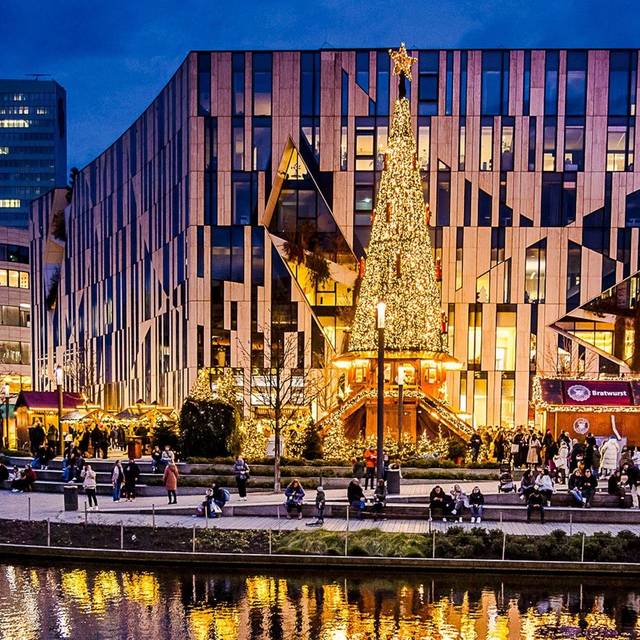 Weihnachtsmärke Überblick: Der Weihnachtsmarkt rund um den Kö-Bogen II. Die Buden sind beleuchtet und verströmen eine weihnachtliche Stimmung.