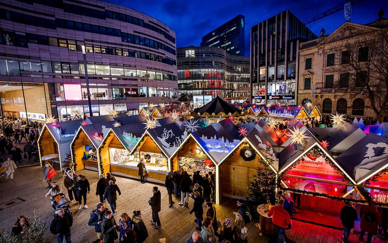 Weihnachtsmärke Überblick: Der Weihnachtsmarkt auf dem Schadowplatz. Mit vielen bunten Buden. Im Hintergrund ist der Kö-Bogen II zu erkennen.