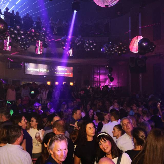 Eine feiernde Menschenmenge in der Nachtresidenz. Viele Lichtquellen an der Decke kreieren eine Party-Atmosphäre.