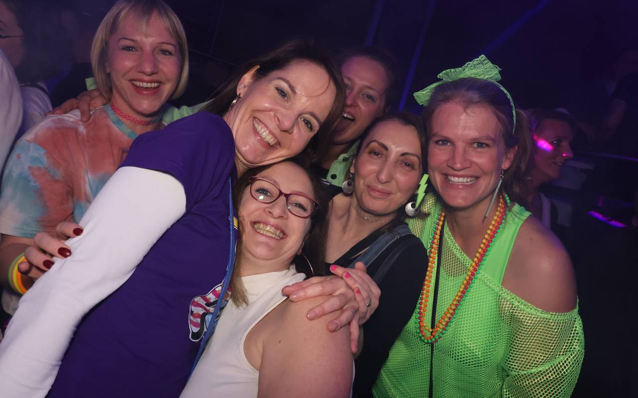 90er-Party: Vier Damen machen ein gemeinsames Gruppenfoto in der Nachtresidenz. Teilweise sind sie im 90er-Jahre-Stil mit Neonfarben gekleidet. Sie lachen und sehen glücklich aus.