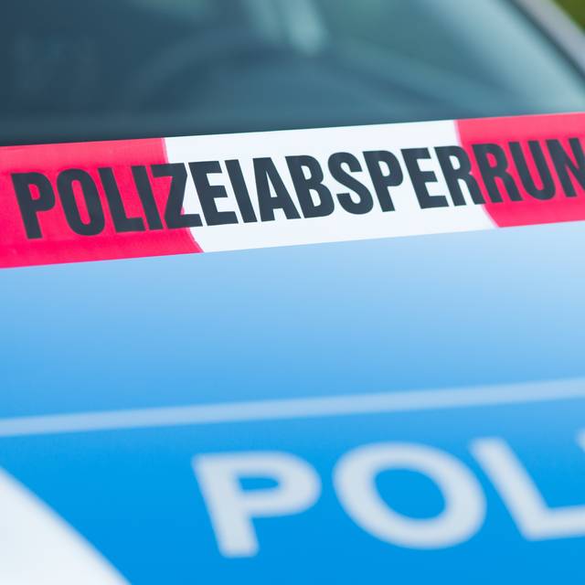 Absperrband vor einem Polizeiauto.