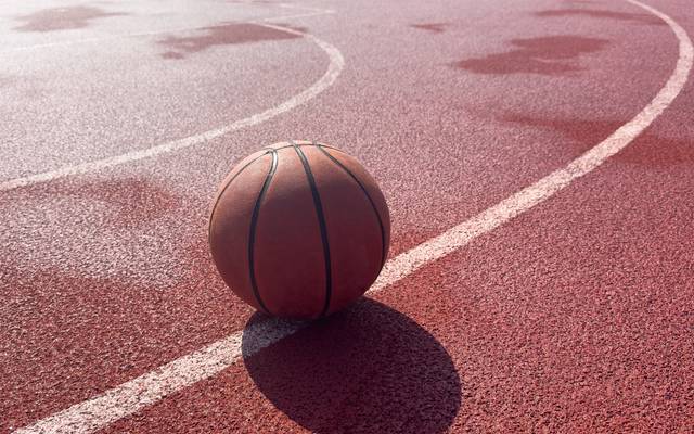 Ein Basketball liegt auf einem Basketball-Court.
