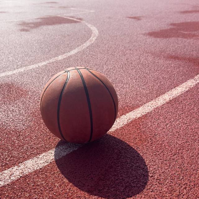 Ein Basketball liegt auf einem Basketball-Court.